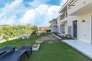 Un bâtiment moderne doté d’un jardin bien entretenu, d’un espace extérieur aménagé et offrant une vue dégagée sur le ciel.