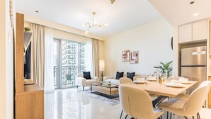 Un soggiorno moderno con angolo ristoro, cucina e balcone con vista sulla città.
