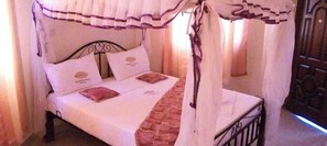 A bed with a canopy, pillows, and a blanket. - The Black Gold Hotel Lokichar (Lokichar)