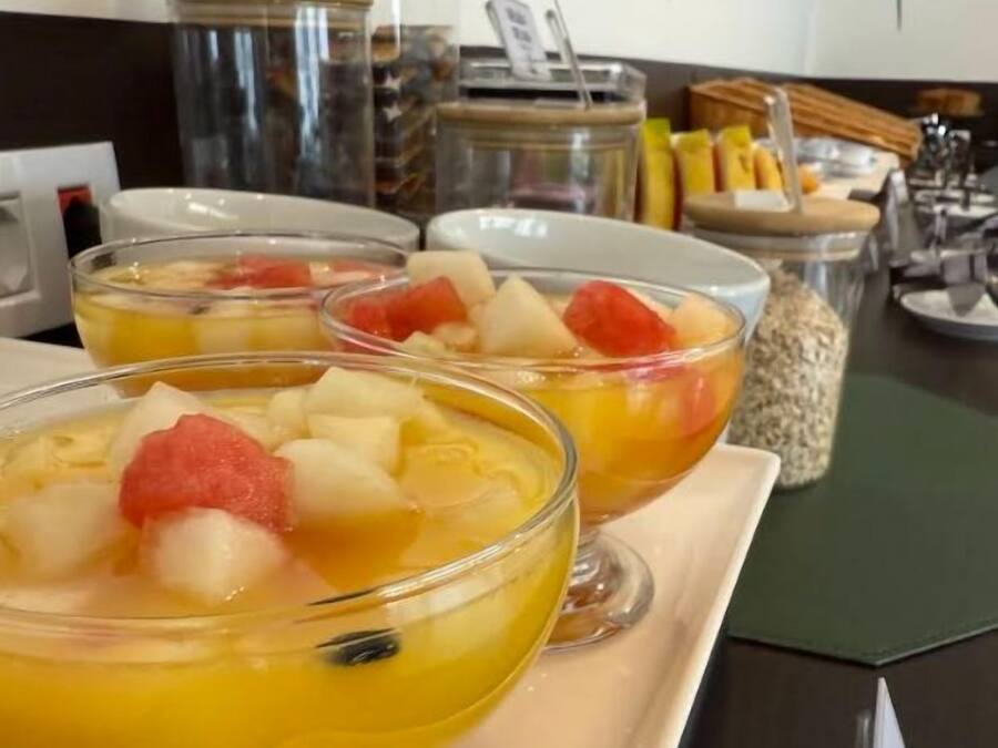 A breakfast buffet with fruit bowls and a variety of food items.