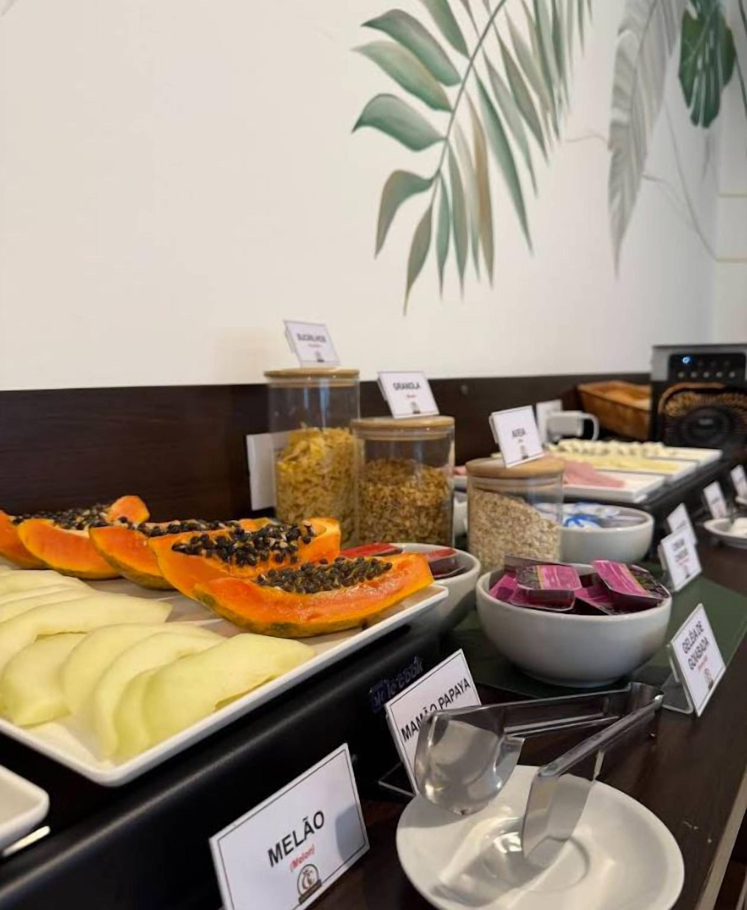 A buffet with various food items including papaya, melon, and other fruits.