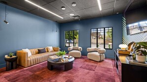 A modern lounge area with a sofa, armchairs, a coffee table, and a desk with a lamp and plants. - Solstice Haven - Desert Sky Getaway (Mesa)