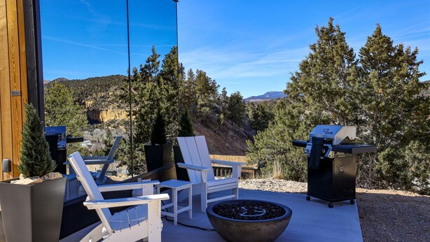 An outdoor seating area with chairs and a fire pit, overlooking a mountainous landscape. - Chic Tiny House with Outdoor Espace to Relax in Orderville, Utah (Orderville)