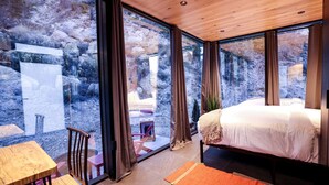 A bedroom with a bed, a wooden table, and a chair. - Chic Tiny House with Outdoor Espace to Relax in Orderville, Utah (Orderville)