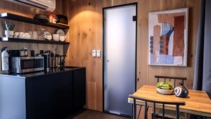 A modern kitchen with a microwave, coffee maker, and utensils on the counter. - Chic Tiny House with Outdoor Espace to Relax in Orderville, Utah (Orderville)