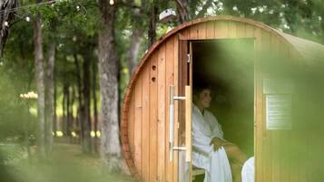 Een sauna met een houten buitenkant, een deur en een bord met tekst.