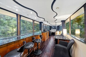 Un intérieur moderne comprenant un espace repas, un bar et des coins salon.