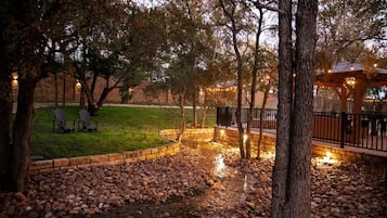 A landscaped outdoor area with a stone pathway, seating, and a gazebo.