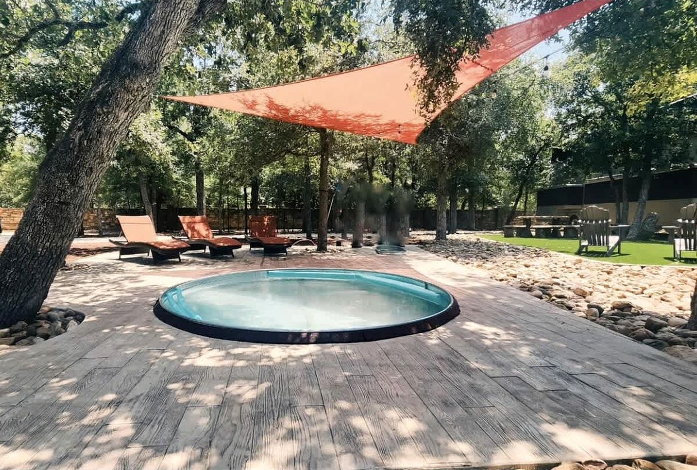 Un bain à remous entouré de chaises longues et d’une terrasse en bois.