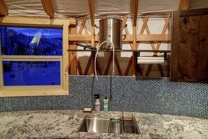 A kitchen with a large window, a stainless steel pot, and a sink. - Wonderful Yurt with Sauna and Incredible Mountain Views in Boise, Idaho (Boise)