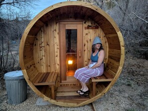A wooden sauna with a bench and a door, surrounded by natural landscape. - Family Friendly Cabin with BBQ in Glendale, Utah (Glendale)