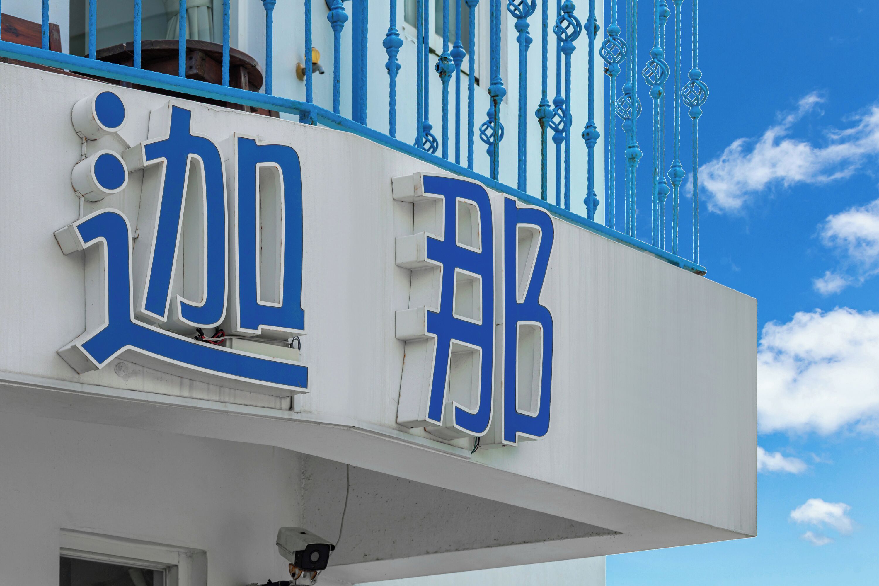Un bâtiment dont la façade est ornée de grandes lettres bleues formant l’inscription « ER ».