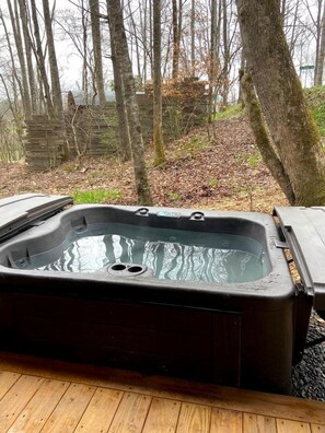 A hot tub on a wooden deck with a forest backdrop. - Glamping Getaway in Pisgah Forest in this Lovely Airstream Rental in North Carolina (Pisgah Forest)
