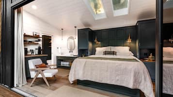 Een slaapkamer met een bed, nachtkastjes, een spiegel en een raam met uitzicht.