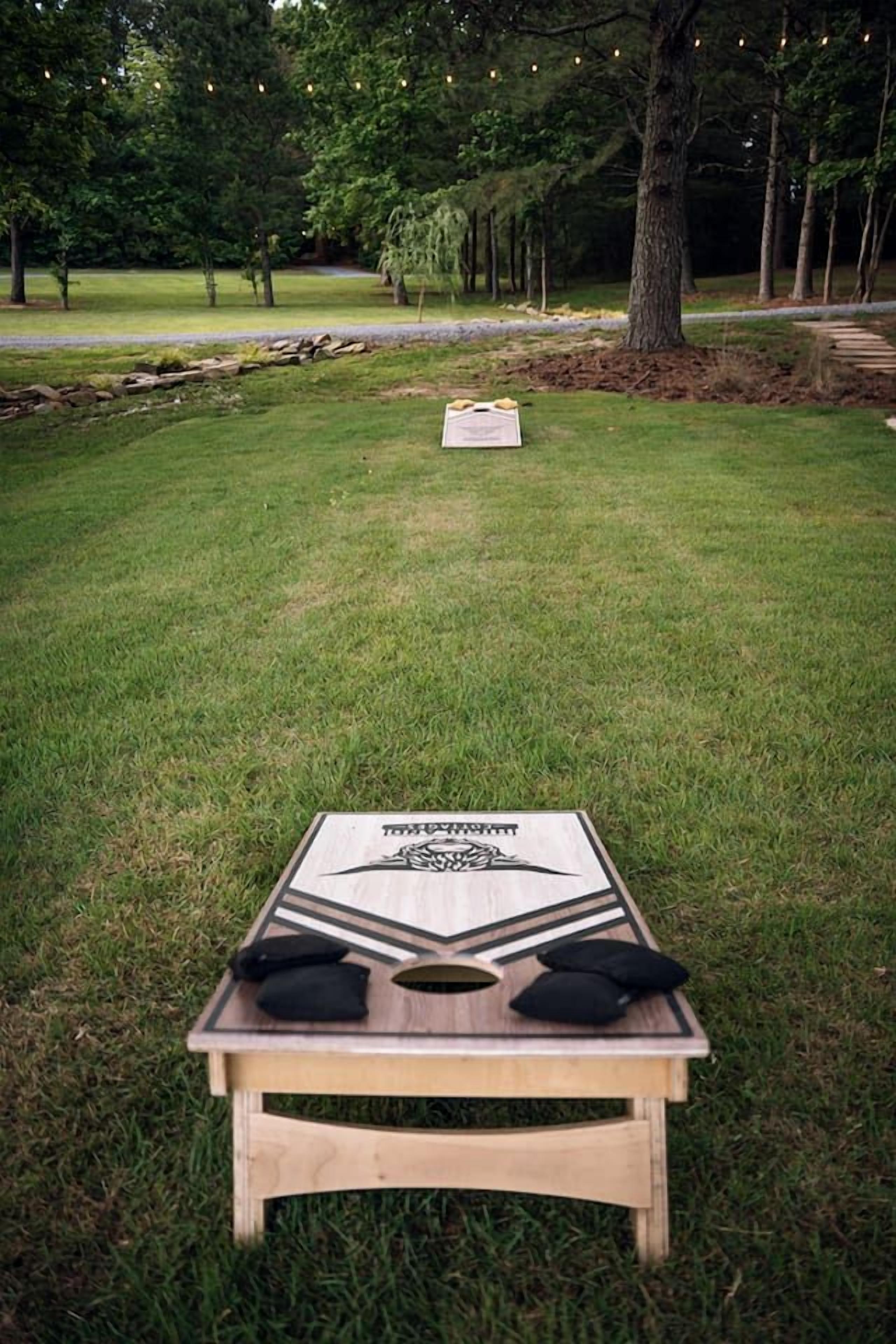 A wooden bench with a table in a grassy outdoor area.