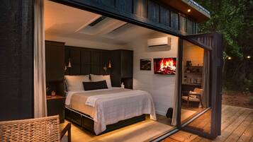 A bedroom with a bed, bedside tables, and a TV.