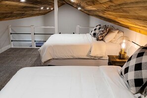 A bedroom with two beds, a wooden ceiling, and a nightstand with a lamp. - Outstanding Cabin Incredible for Six People in Livingston, Texas (Livingston)