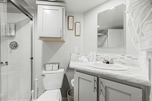 A bathroom with a shower, toilet, sink, and cabinet. - Heavenly Cabin Incredible for Groups Escapes in Texas (Fredericksburg)