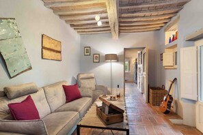A cozy living room with a sofa, a coffee table, a lamp, and a guitar. - Relaxing Retreat With Personalized Chef Cooking Class & Relaxation Services (San Casciano dei Bagni)