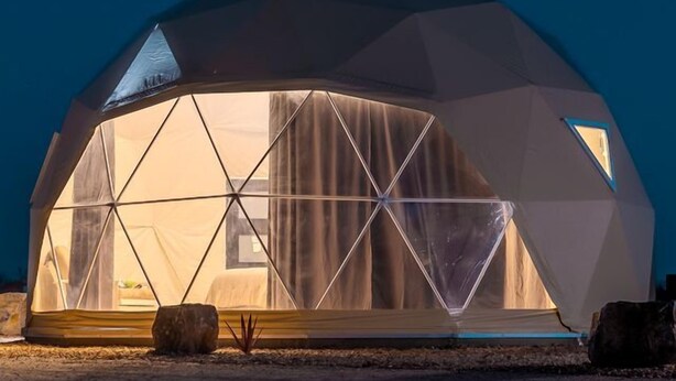 A geodesic dome structure with a transparent interior, a visible bed, and a small table. - Wonderful Secluded Dome in Willcox, Arizona (Wilcox)