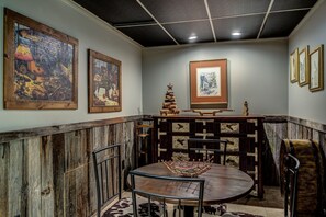A dining area with a round table, chairs, and a rustic wooden wall. - Incredible Cabin with Hot-tub, Fire Pit and Petting Zoo in Sugar Grove, North Carolina (Sugar Grove)