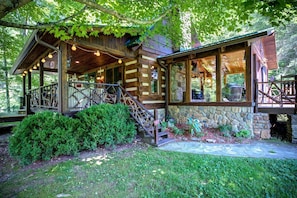 A rustic cabin with a stone foundation, wooden exterior, and a porch with a railing. - Incredible Cabin with Hot-tub, Fire Pit and Petting Zoo in Sugar Grove, North Carolina (Sugar Grove)