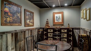 Un coin repas avec une table ronde, des chaises et un mur en bois rustique.
