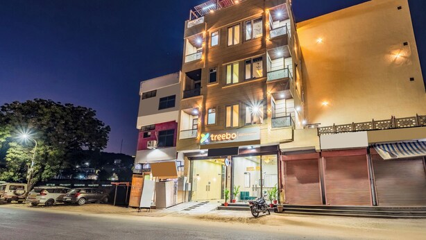 Un hôtel à plusieurs étages, avec une enseigne indiquant « Treebo » et une entrée bien visible.