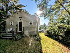A single-story house with a front porch, a small window, and a door. - Gorgeous Waterfront Cabin for an Unforgettable Family Vacation by Georges Pond in Franklin, Maine (Franklin)