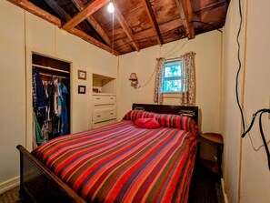A bedroom with a bed, a wardrobe, a dresser, a window with curtains, and a lamp. - Gorgeous Waterfront Cabin for an Unforgettable Family Vacation by Georges Pond in Franklin, Maine (Franklin)