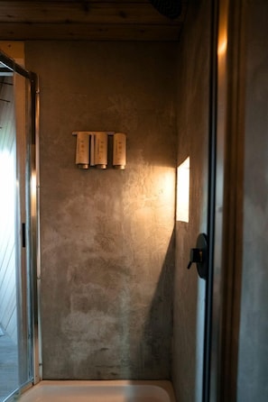 Ein Badezimmer mit einer Badewanne, einem Handtuchhalter mit drei Handtüchern und einem Fenster, das natürliches Licht hereinlässt.