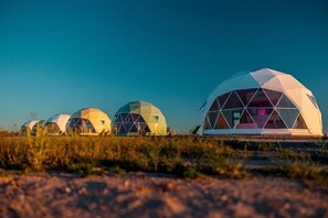 A row of geodesic dome structures with transparent walls, set in a natural landscape. - Impressive Dome with Great Panoramic Desert Views in Willcox, Arizona (Wilcox)