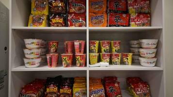 A pantry shelf stocked with various food items including packaged meals, canned goods, and condiments.