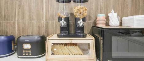 Una cocina con cocina de arroz, licuadora, microondas y una caja de madera con palillos.
