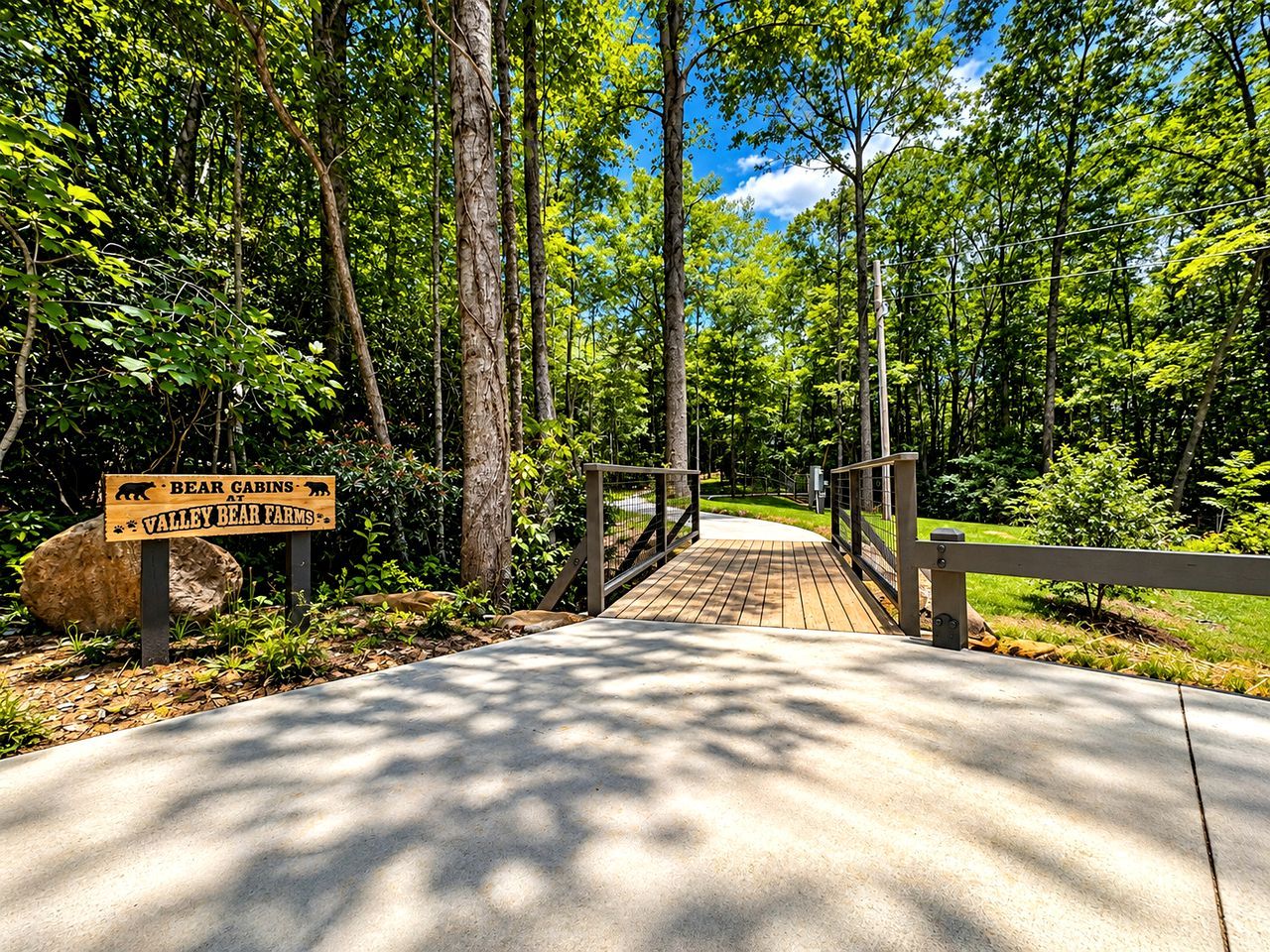 A wooden bridge leading to a sign for Bear Cabins at Valley Bear Farms.