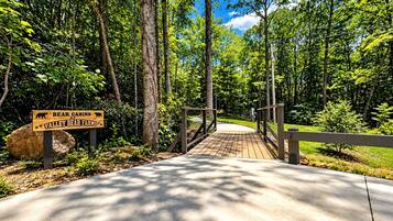 A wooden bridge leading to a sign for Bear Cabins at Valley Bear Farms.