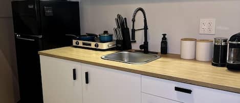 Una cocina moderna con estufa integrada, un fregadero y armarios blancos.