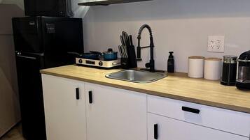 Coffee/tea maker, fridge, microwave, dining table