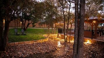 A landscaped outdoor area with a stone pathway, seating, and a gazebo.