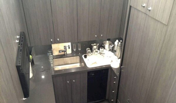 Una cocina compacta con lavabo, armarios y lavavajillas.