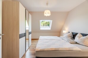A bedroom with a bed, bedside lamps, a window, and a ceiling light. - Apartment 'Kirschblüte' with Mountain View, Shared Garden and Wi-Fi (Oberkirch)
