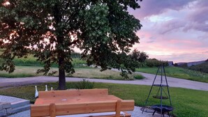 A wooden bench, a swing, and a paved area with a tree. - Apartment 'Kirschblüte' with Mountain View, Shared Garden and Wi-Fi (Oberkirch)
