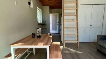 A loft-style room with a wooden staircase, a dining table, and a bench.