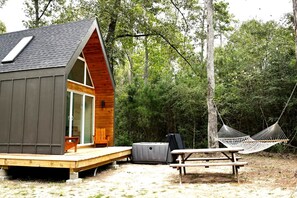 A cabin with a deck, a hammock, and a picnic table. - Impressive Cabin with Hammock in Montgomery, Texas (Montgomery)
