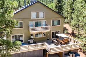 A two-story building with a balcony, outdoor seating, and a covered patio area. - Luxurious Cabin with Game Room, Amazing Deck and Spa in California (Big Bear Lake)