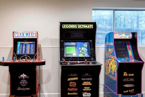 Trois bornes d’arcade avec les titres et logos des jeux clairement visibles.