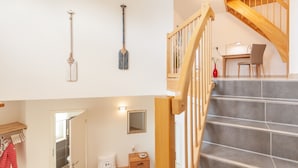 A staircase with wooden railings leading to a desk area with a chair and a small table. - Modern vacation home with plenty of space to relax - Haus Eleganza (Glowe)