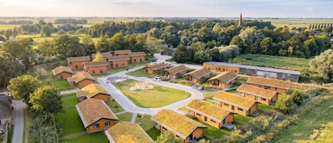 A residential area with multiple houses, a central open space, and a distant church spire.