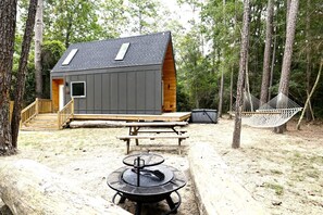 Een chalet met terras, picknicktafel, hangmat en barbecue.
