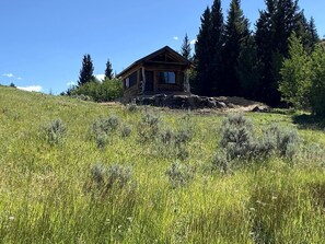 A cabin on a hill with a clear sky.